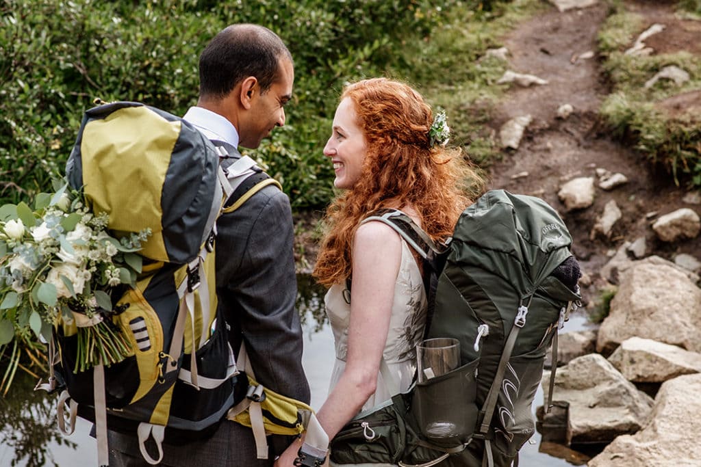 a man and woman with backpacks standing next to each other