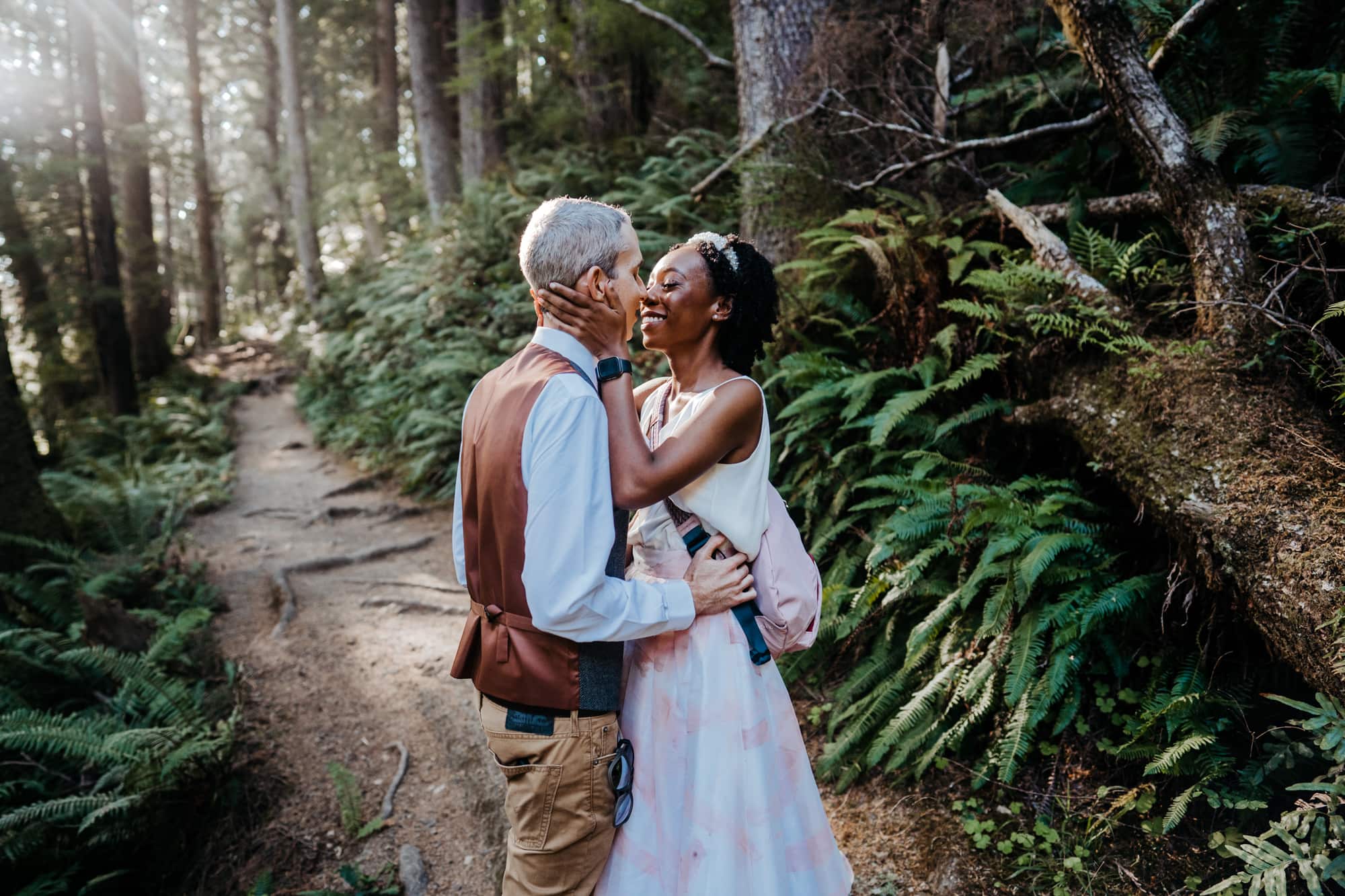 an older couple embracing each other in the woods