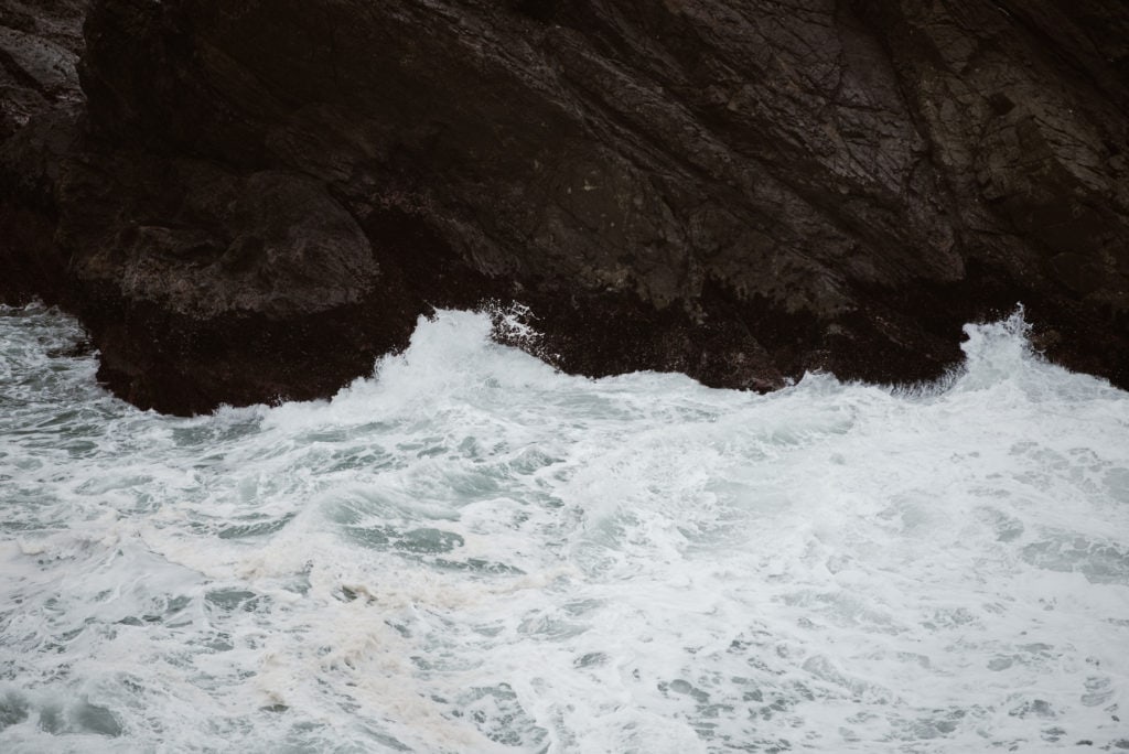 the water is crashing against the rocks near the shore