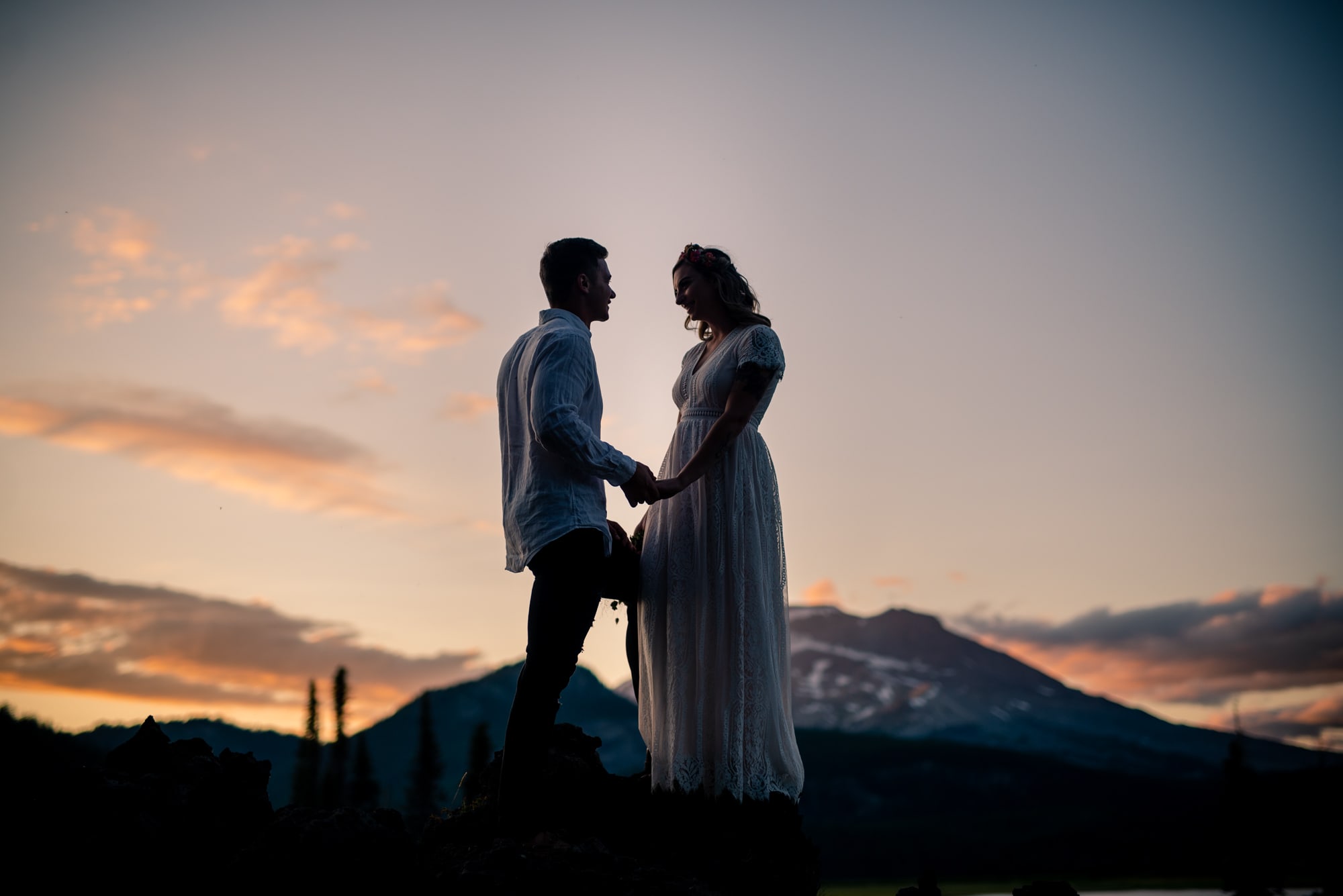 a man and woman standing next to each other at sunset