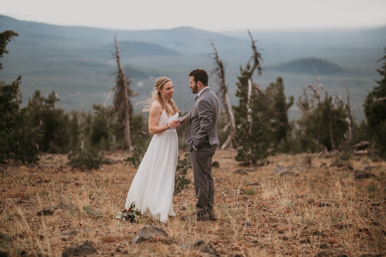 a bride and groom standing on top of Tumalo mountain