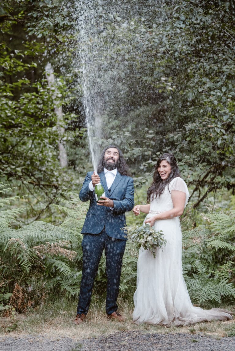 a bride and groom standing under a sprinkler