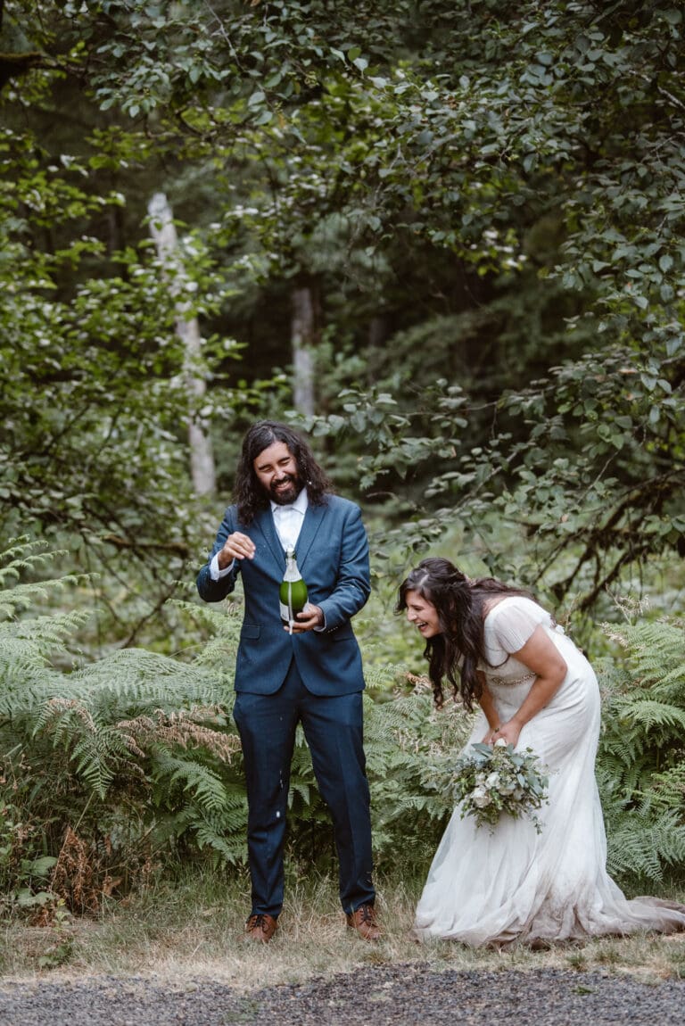 a bride and groom standing in the woods