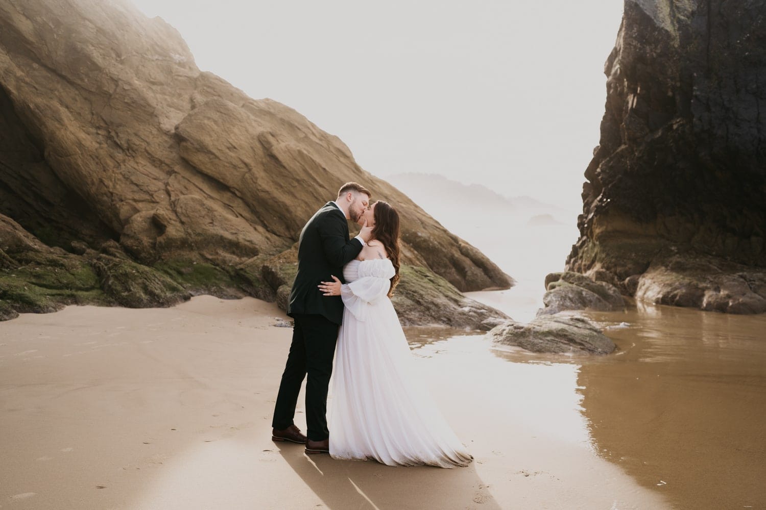 bride and groom kiss during their elopement ceremony at Hug Point near Cannon Beach.