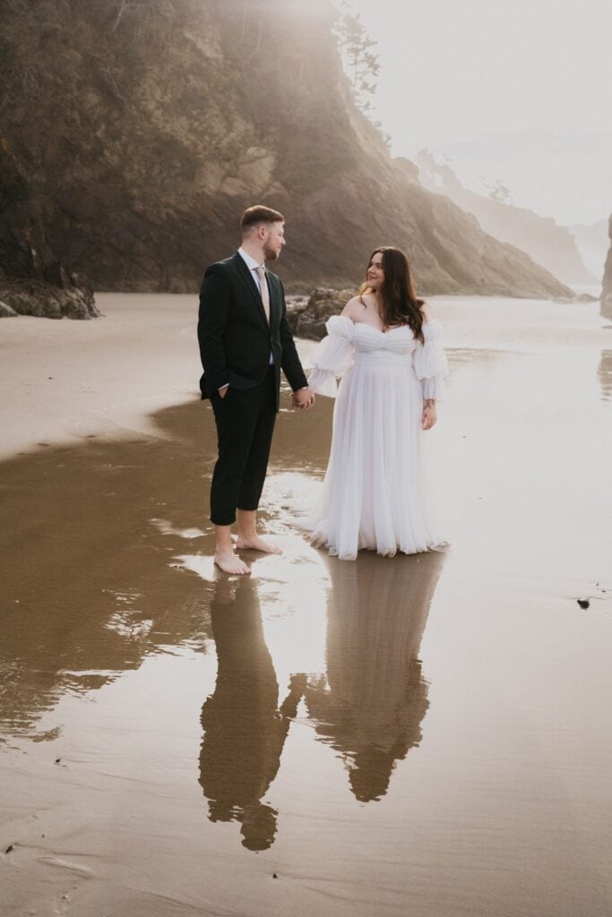 A bride and groom hold hands after getting married in an intimate ceremony at Hug Point near Cannon Beach.