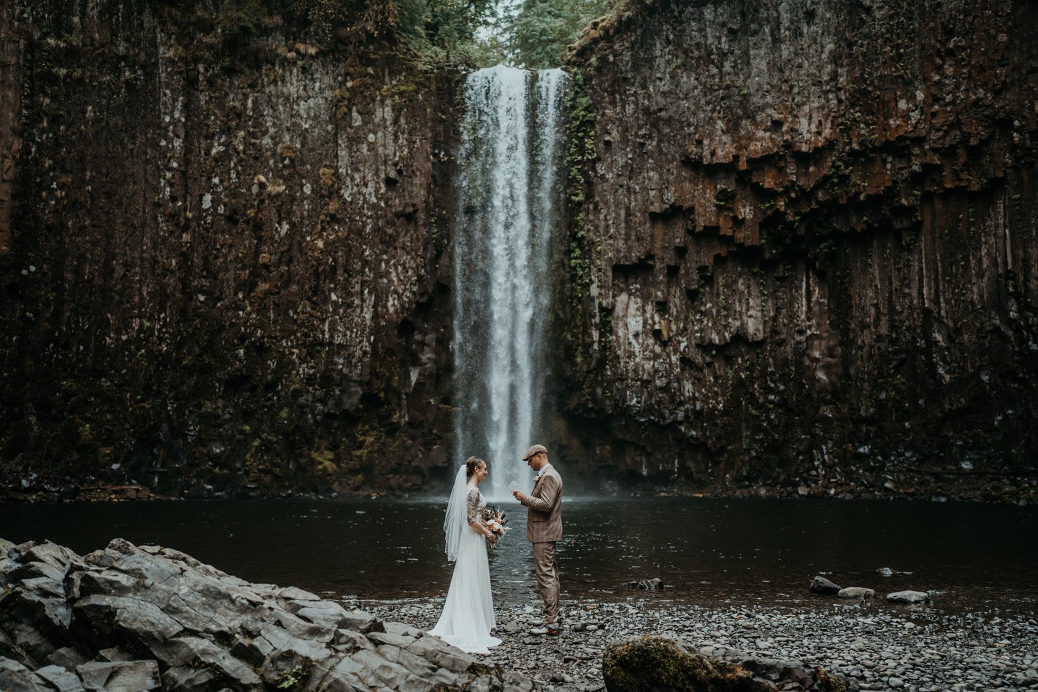 A bride and groom stand in front of Abiqua Falls and exchange wedding vows.